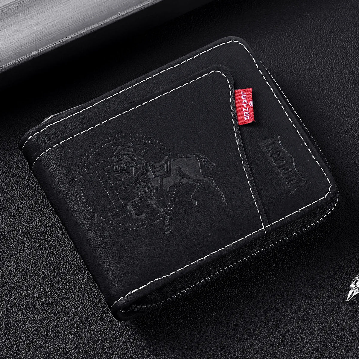 A black leather card clip wallet with a embossed silhouette of a horse and a leather tag.