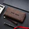 A brown leather wallet with the text Your name embossed on it, lying on a dark surface next to a pen and a red ribbon.