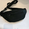 A black compact nylon waist bag with a strap is shown against a white background.