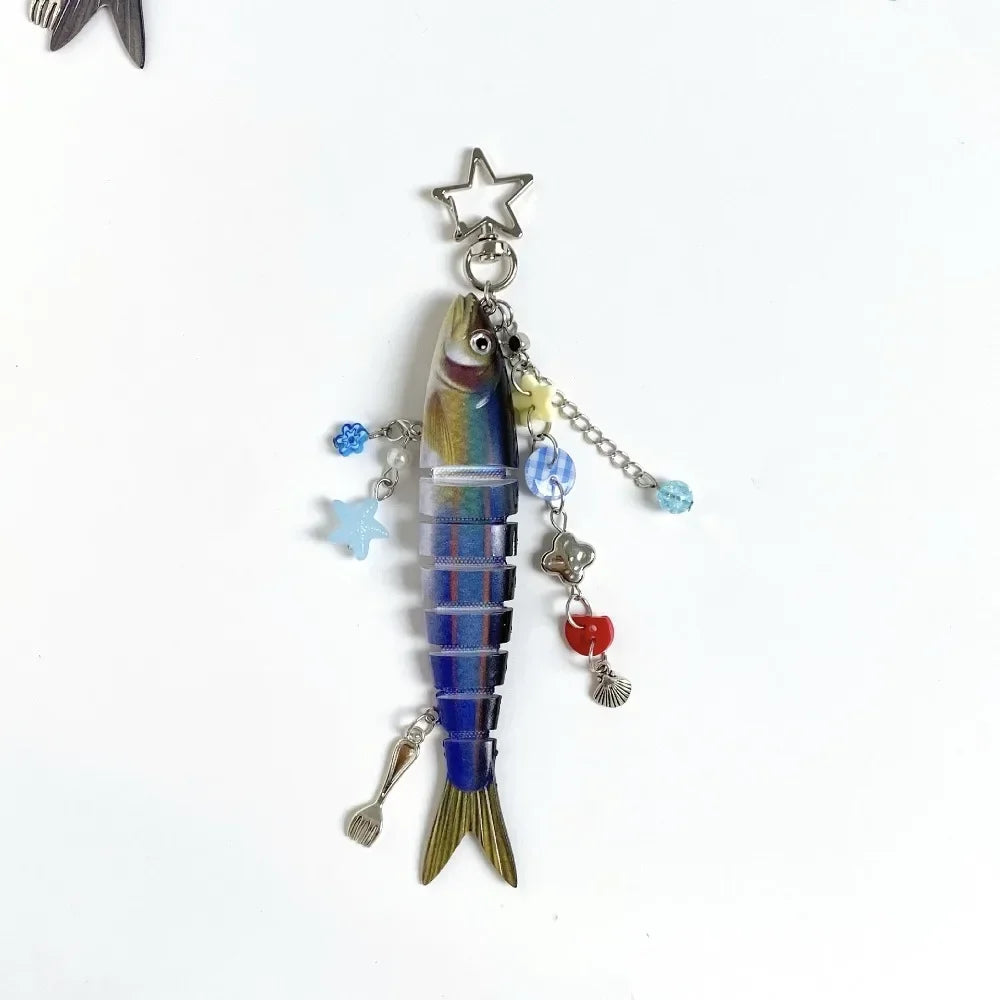 A silver simulation fish keychain with a star charm and dangling beads.