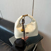 A cream colored retro PU leather shoulder bag with a gold chain strap is displayed on a dark surface.