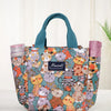 Bolsa bento de tela colorida con gatos y animales de dibujos animados, tapa rosa y asas verde azulado.