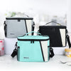 Three insulated reusable lunch bags in gray, black, and mint green are displayed on a white surface.