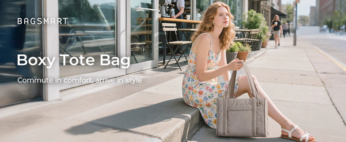 A woman wearing a light floral dress sits on a sidewalk, holding a beige quilted tote bag.