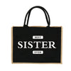 Schwarze Jute-Burlap-Tasche mit weißer Aufschrift: BESTE SCHWESTER JEGEN