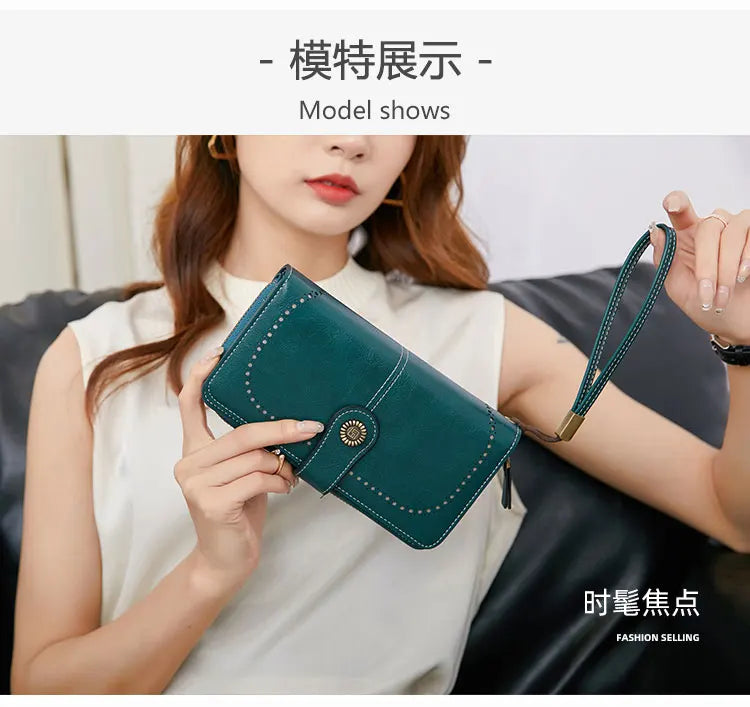 A woman holds a dark green RFID anti-theft multi-card wallet with a leather wrist strap.