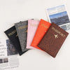 A brown leopard print PU leather passport holder next to a pink and orange passport holder.
