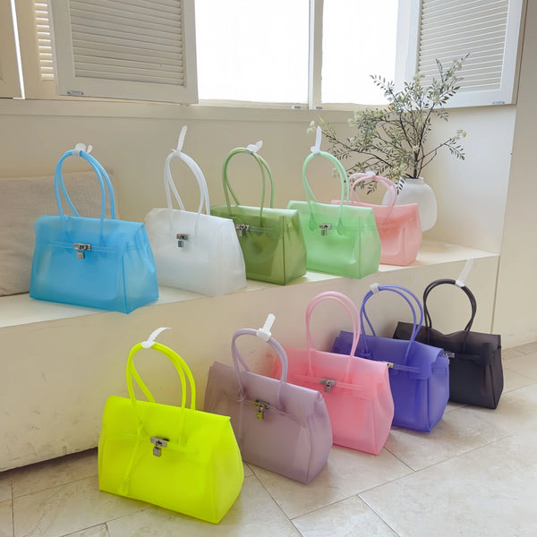 A collection of pastel colored summer jelly shoulder bags displayed on a shelf.