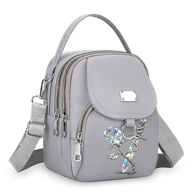 Sac bandoulière floral gris et durable avec fermeture éclair et sangle réglable.