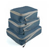 A set of three navy blue and gray reusable compression packing cubes stacked on a white background.
