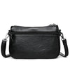 Bolso cruz de cuero negro moderno para mujer con cierre de cremallera y correa de cadena.