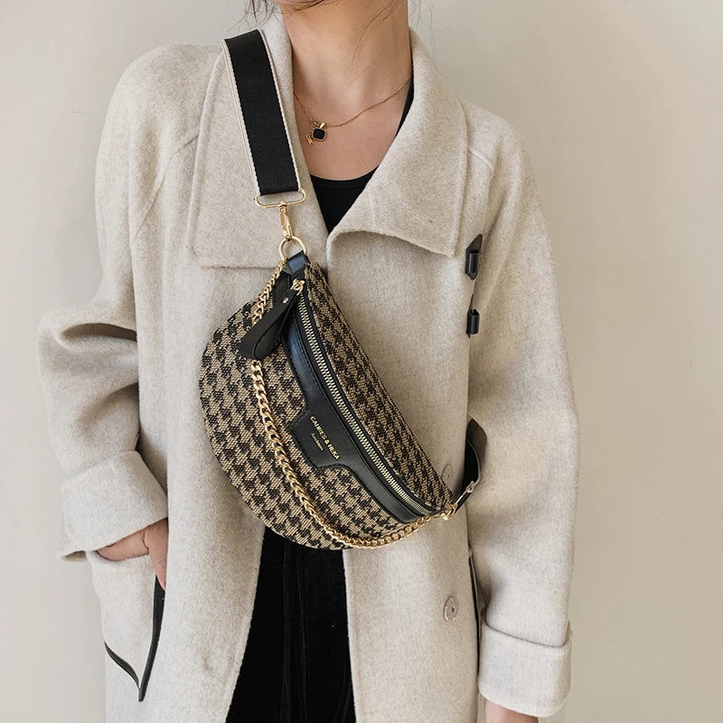 Une femme tient un sac bandoulière à motif léopard avec des éléments dorés et une veste en cuir noir.