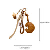 A brown leather croissant shaped keychain with a lanyard and pendant.