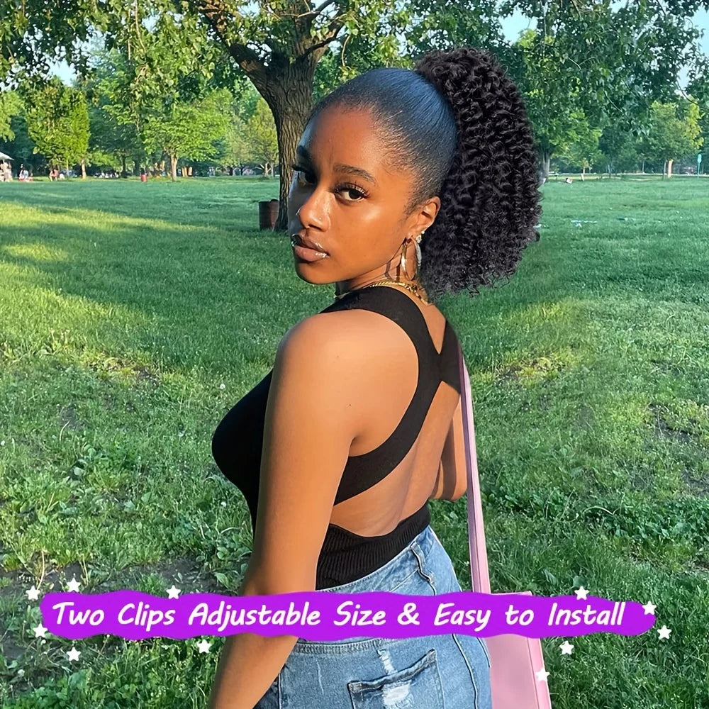 A woman models black kinky curly drawstring hair extensions against a green park background.