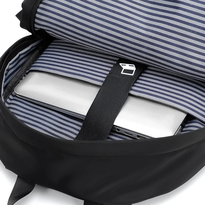 A navy blue and white striped laptop backpack is shown open, displaying a silver laptop inside.
