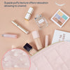 A pink padded makeup bag with a wide-open design featuring various beauty products and a silky fabric.