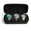 A black leather watch organizer case holding three wristwatches.