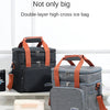 Un paire de sacs à glace doubles en noir et gris avec des sangles orange, exposés sur une surface blanche.