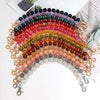 A curved necklace made of colorful resin stone beads strung on a gold-toned chain.