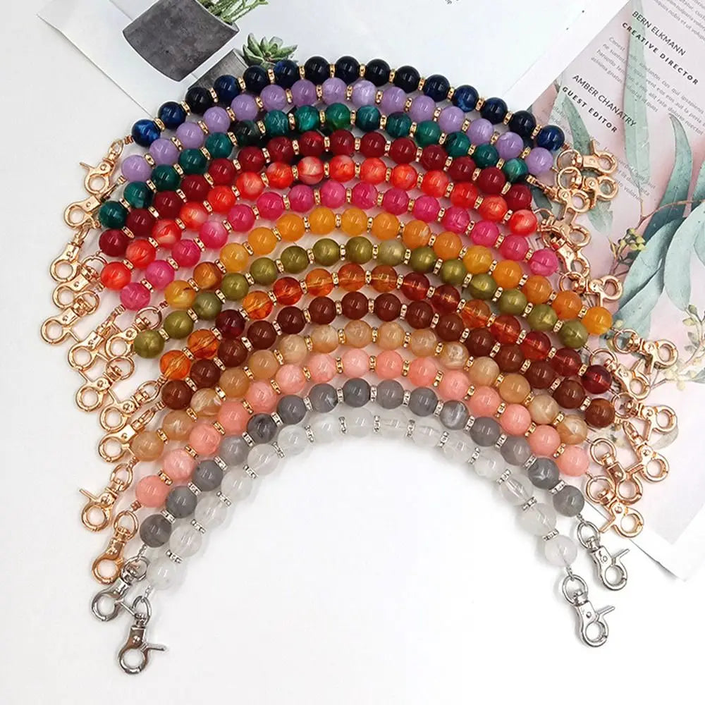 A curved necklace made of colorful resin stone beads strung on a gold-toned chain.