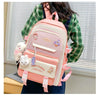 A pink and white nylon backpack set for students featuring cartoon designs, carried by a person.