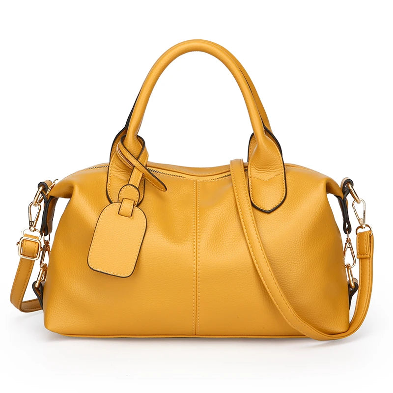 A mustard yellow soft leather tote bag with a top handle and adjustable shoulder strap.