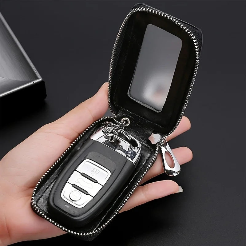 A hand holds an open black PU leather car key case with a metal hook and a clear plastic card inside.