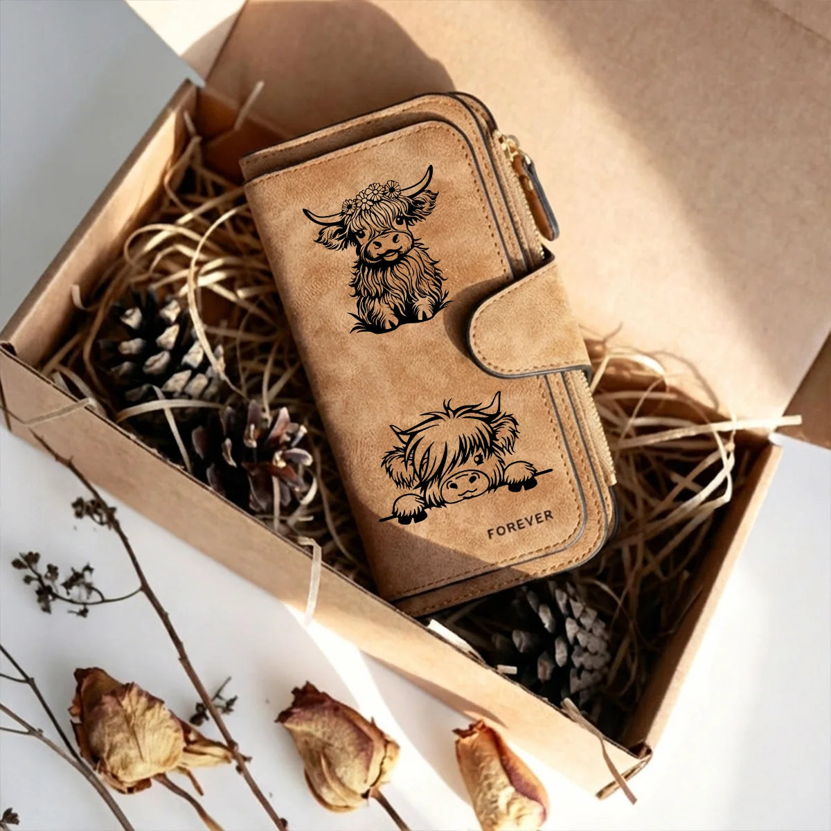 Cartera de cuero PU marrón para vaca con cierre de cremallera y diseño tallado, dentro de una caja de cartón.