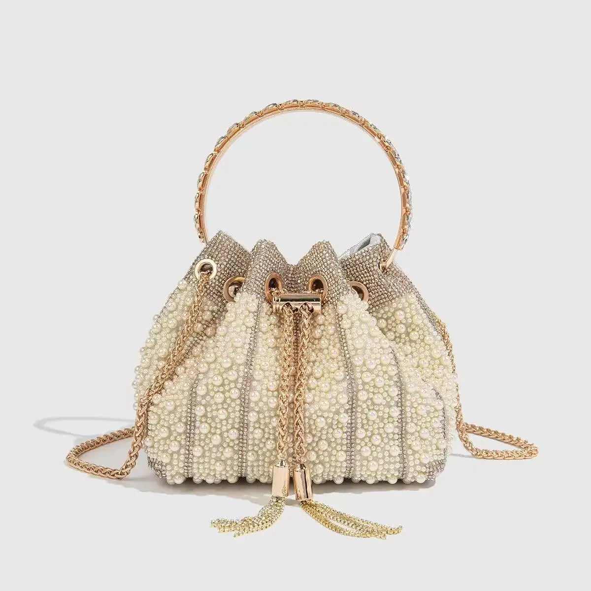 A cream-colored evening clutch embellished with small pearls and gold chain detailing.