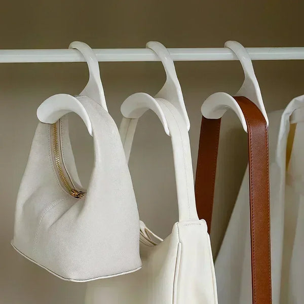 A set of five white and brown bag hangers and hooks for storage organization displayed on a white rack.