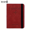 A deep red leather passport holder with a black trim and a silver airplane emblem.
