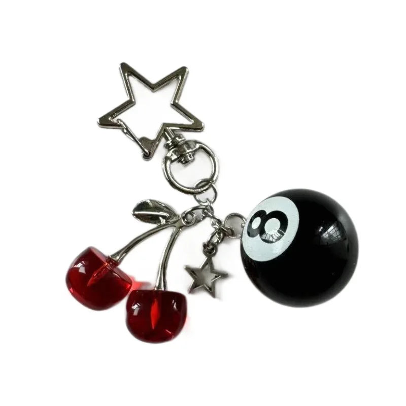 A black and white Y2K 8 ball keychain charm featuring a star and billiard ball design.