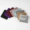 A collection of nine slim leather mini wallets in various shades including purple, maroon, pink, and gray.