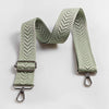 A light sage green adjustable handbag strap featuring an arrow jacquard pattern.
