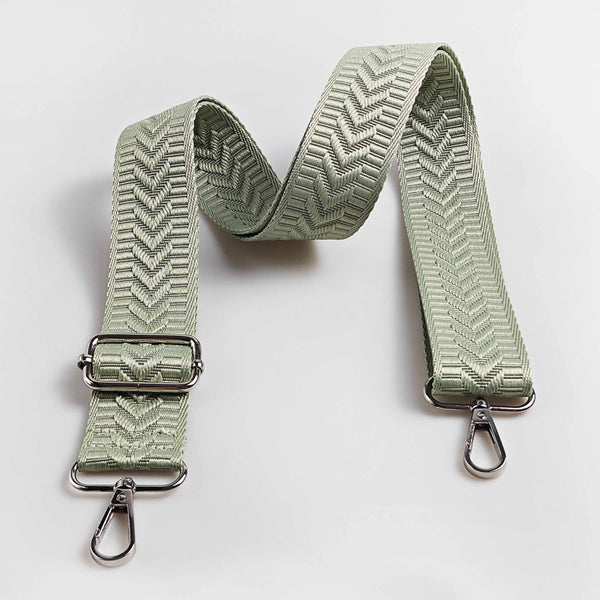 A light sage green adjustable handbag strap featuring an arrow jacquard pattern.