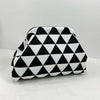Pochette de plage en crochet à motif géométrique noir et blanc, sur une surface blanche.