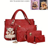 A red fashion embossed PU handbag set featuring a large tote and a smaller wallet, displayed next to teddy bear pendants.
