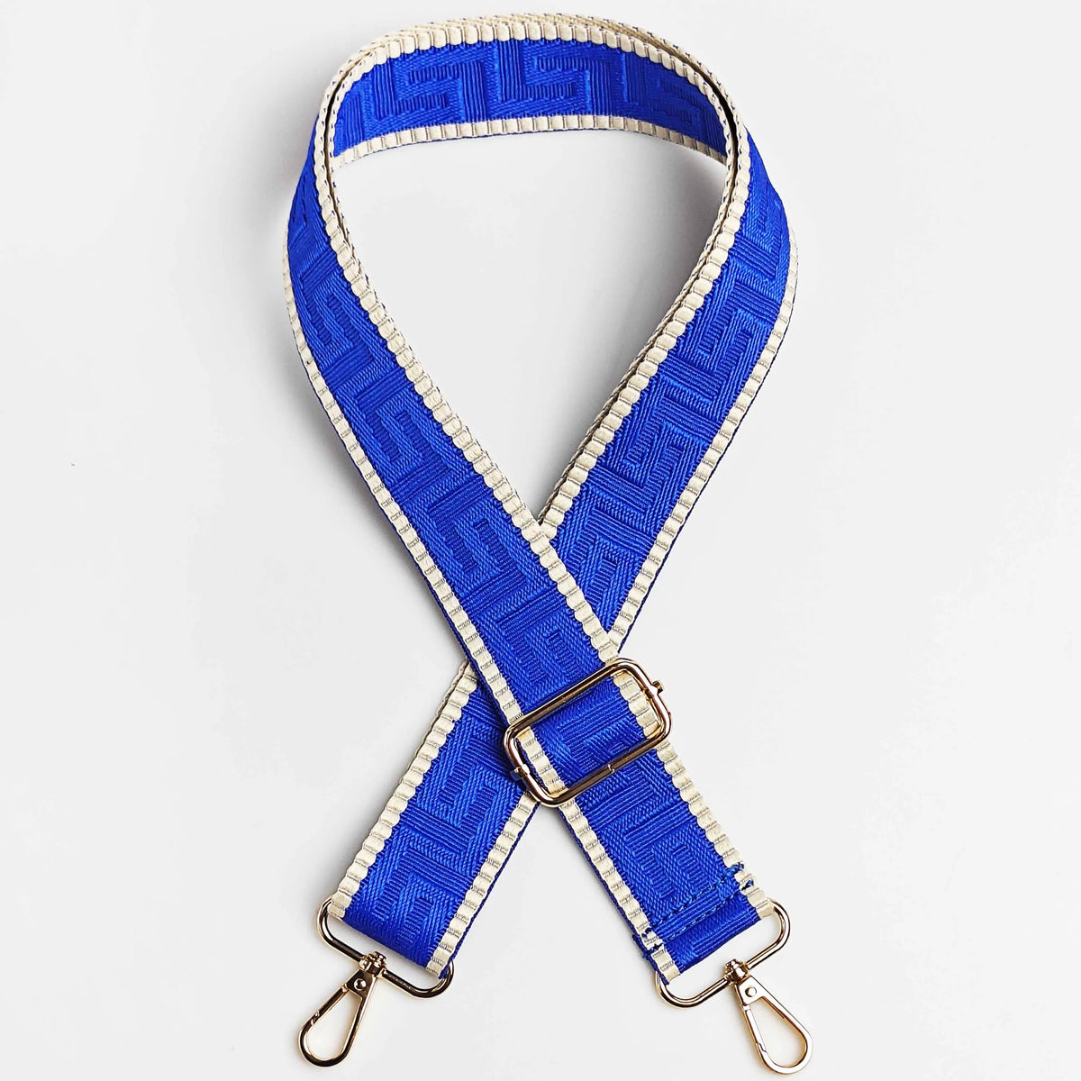 A blue and beige patterned adjustable crossbody bag strap with a gold buckle.