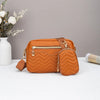 Orange gepolstertes Crossbody-Taschen mit weißem Krug und getrockneten Blumen im Hintergrund