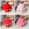 A set of three cute plush rabbit bag charms in red and pink colors displayed on cardstock.