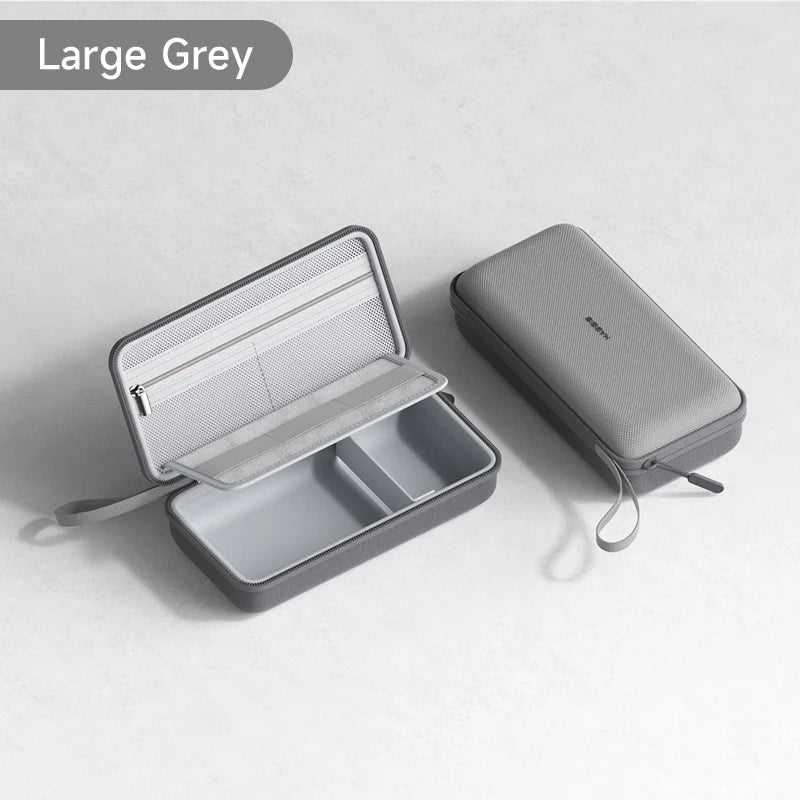 Una bolsa portátil gris grande para organizar cables, abierta mostrando un compartimento interior.