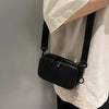 A black striped PU leather shoulder bag is shown hanging from a black strap against a light-colored shirt.