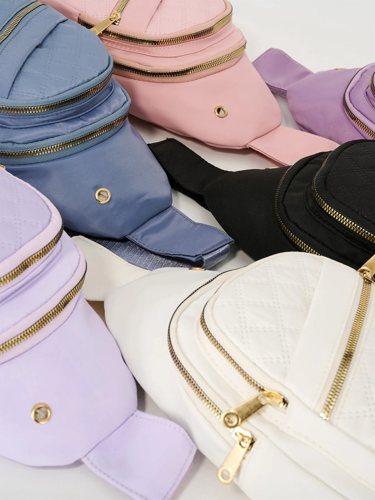 Collection de sacs bandoulière matelassés de diverses couleurs : rose, violet, bleu et noir.