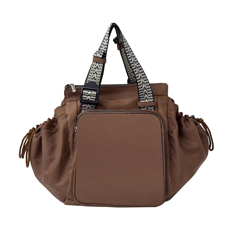 A brown nylon shoulder bag with a patterned strap and a flap closure.