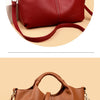 A luxury soft leather women's tote bag in a deep burgundy color shown from the side.