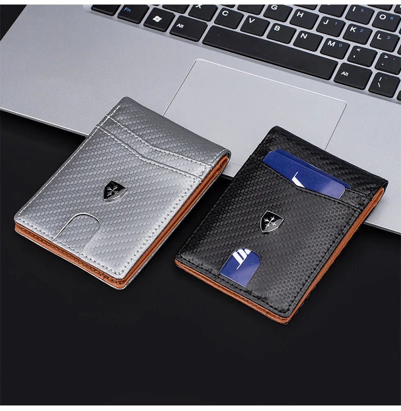 A black leather wallet with a money clip and a blue card, placed on a laptop keyboard.