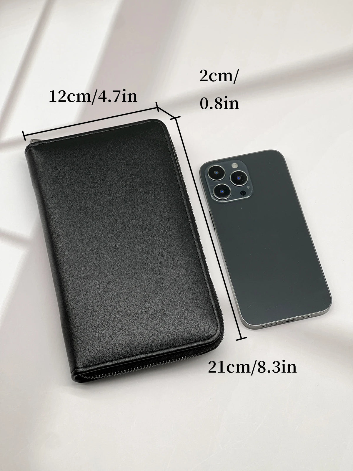 A black multi-card commuter wallet next to an iPhone, showing the dimensions of both items.