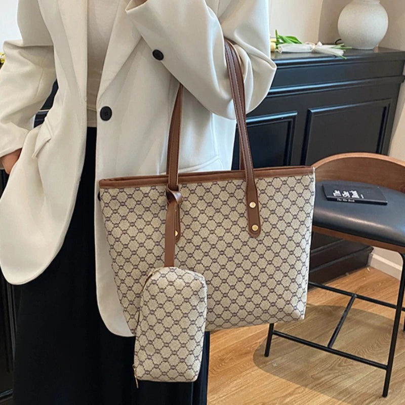 A beige geometric tote bag with brown leather trim is carried by a person wearing a white coat.