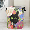 A foldable storage basket decorated with a colorful floral pattern featuring a black cat face.
