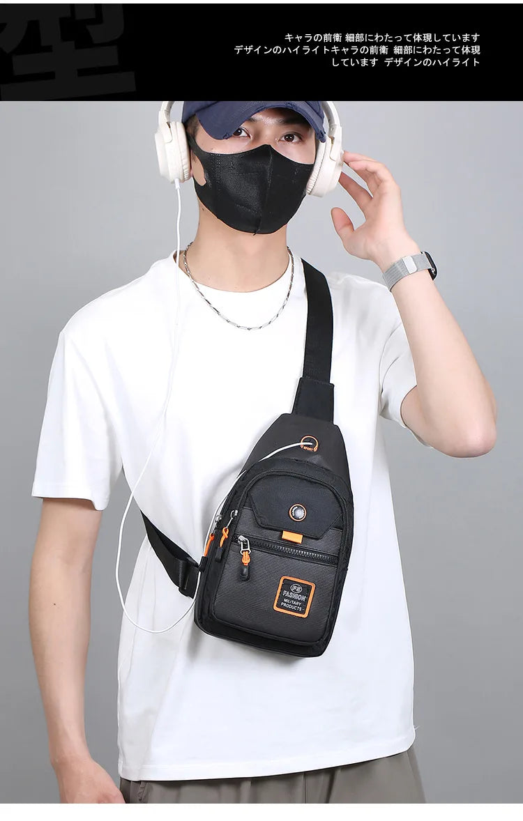 A person wearing a black face mask and headphones holds a black Oxford crossbody sling bag against a white t-shirt.